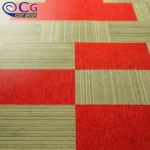 A close-up of carpet tiles in a checkerboard pattern with red and green sections.