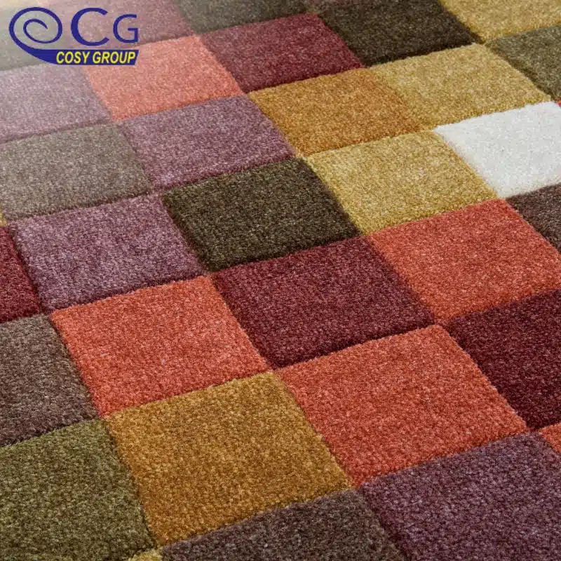 A close-up of colorful carpet tiles in shades of red, brown, and yellow arranged in a checkerboard pattern.