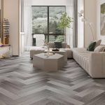 A stylish living room with herringbone laminate flooring, modern furniture, and large windows with a scenic view.