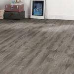 A room with light gray vinyl flooring, storage boxes, and a framed picture on the wall.